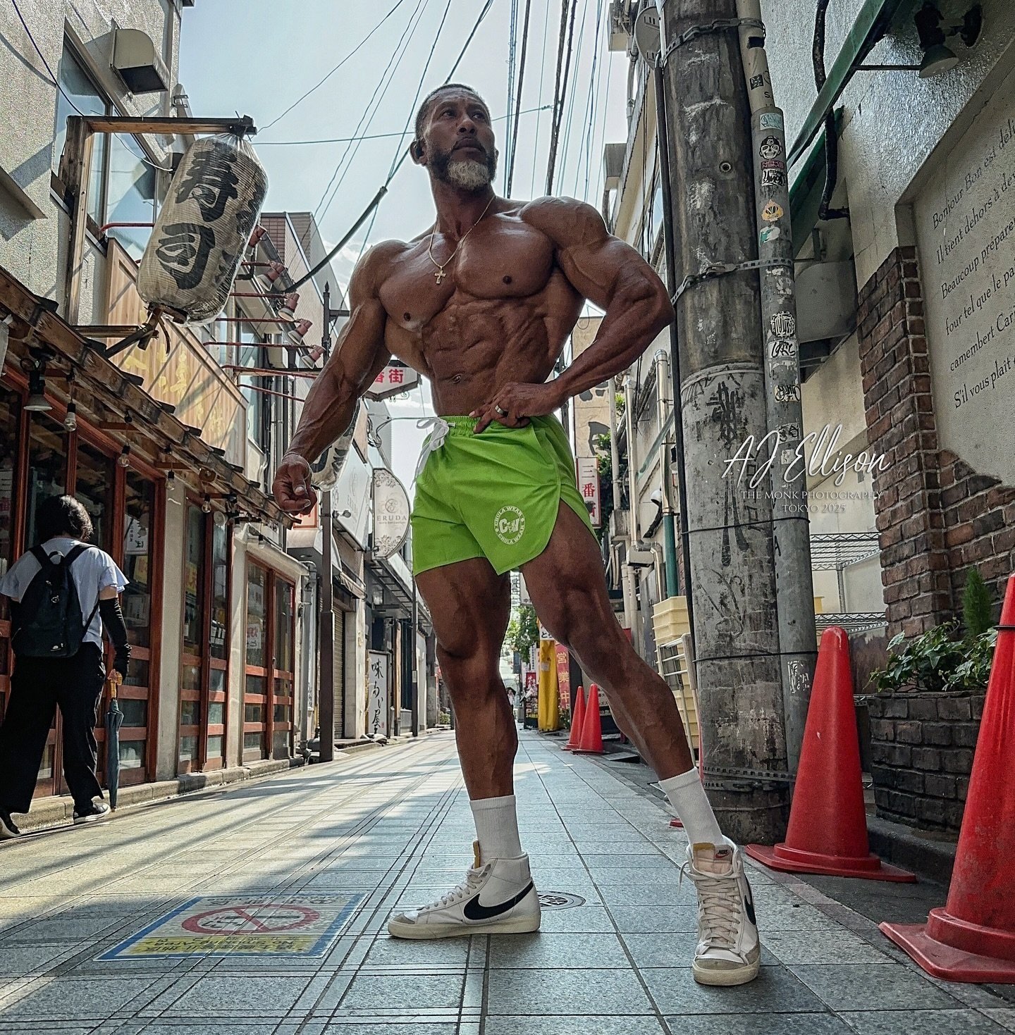 AJ Ellison posing on a street in Tokyo during Olympia week 2025