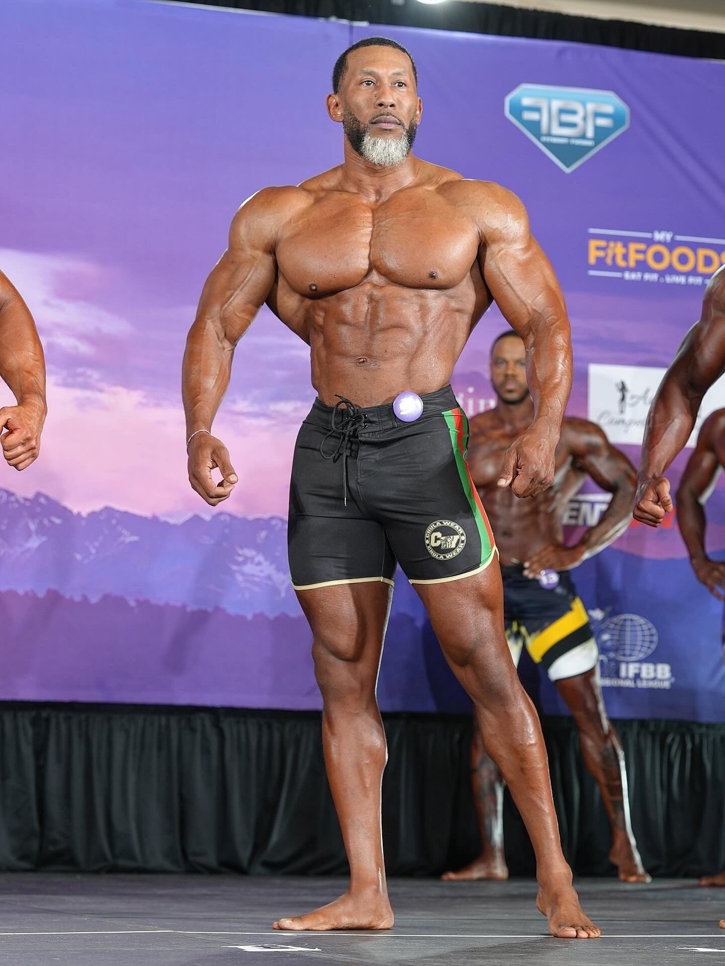 AJ Ellison competing on an IFBB Pro League stage in 2025