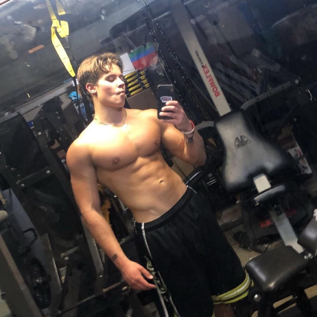 A young Alex Eubank taking a mirror selfie in a home gym during his early training days