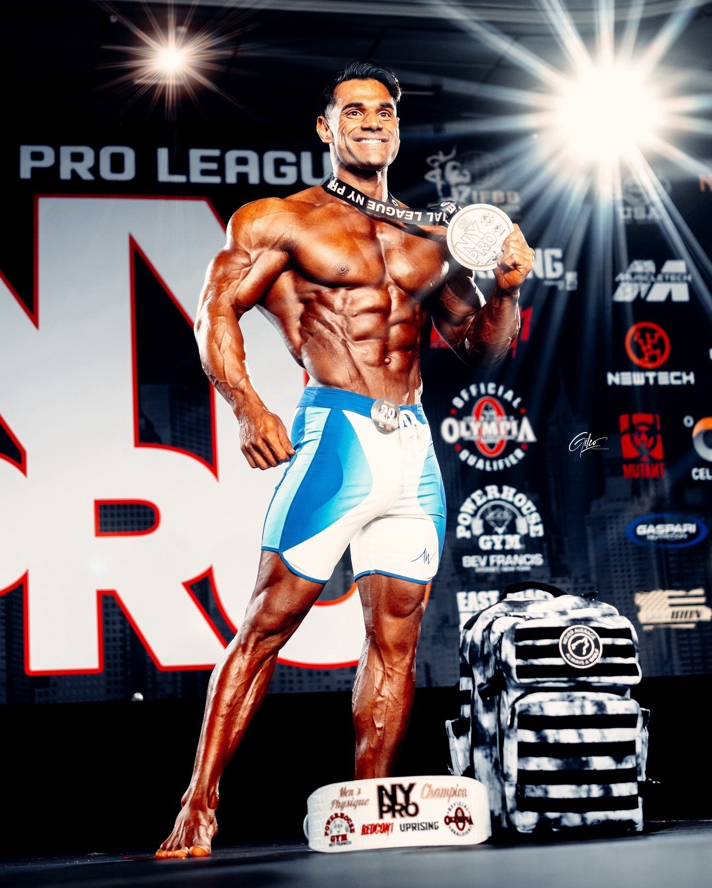 Ali Bilal holding his New York Pro champion medal on stage