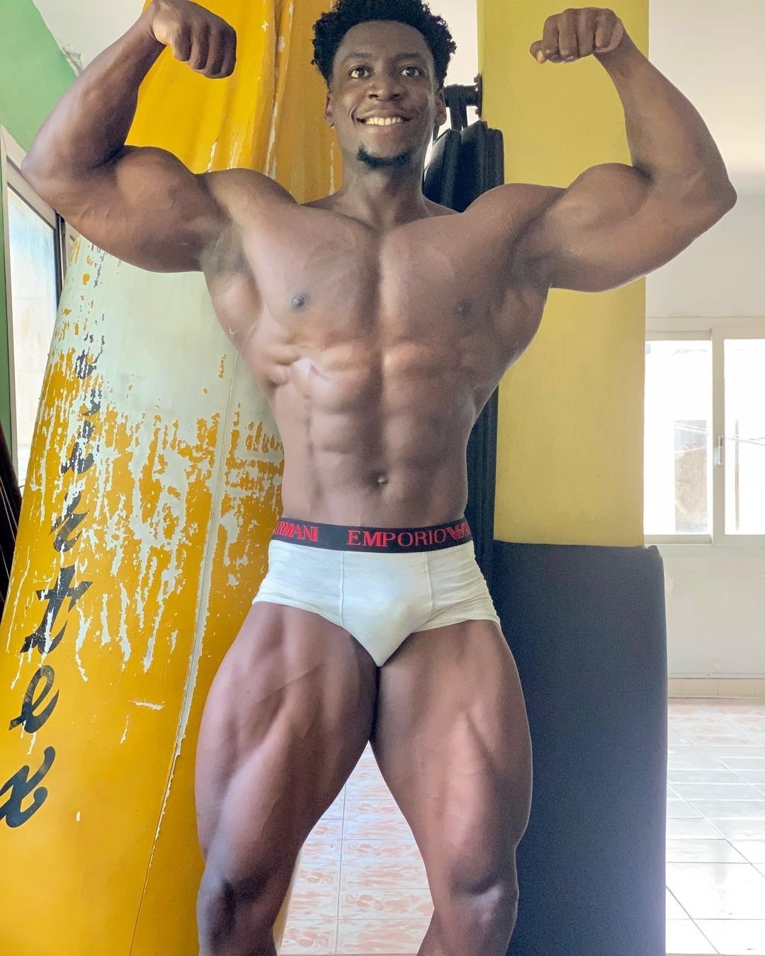 Amouzou Caleb hitting a front double-biceps pose