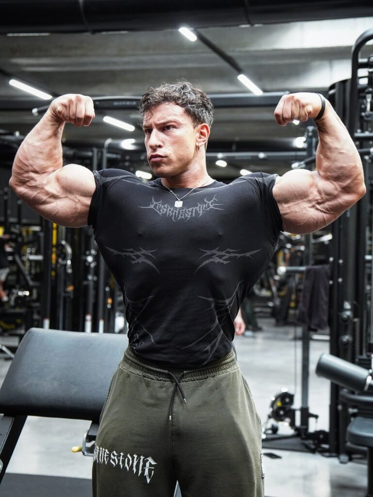 Andrea Mammoli flexing a front double biceps in the gym during his off-season