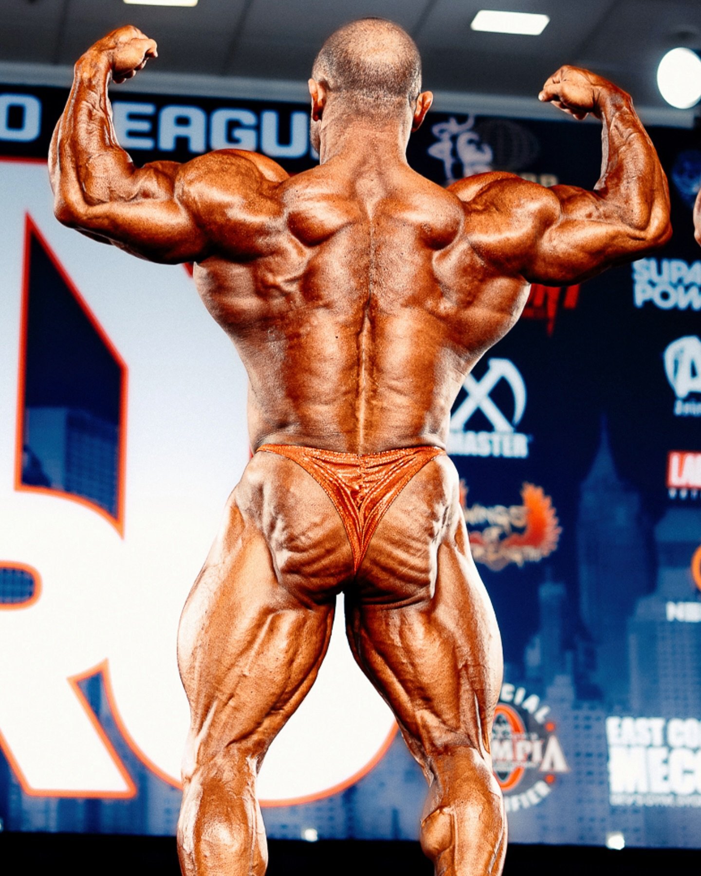 Angel Calderon Frias performing a back double biceps pose, showing his back thickness and leg development