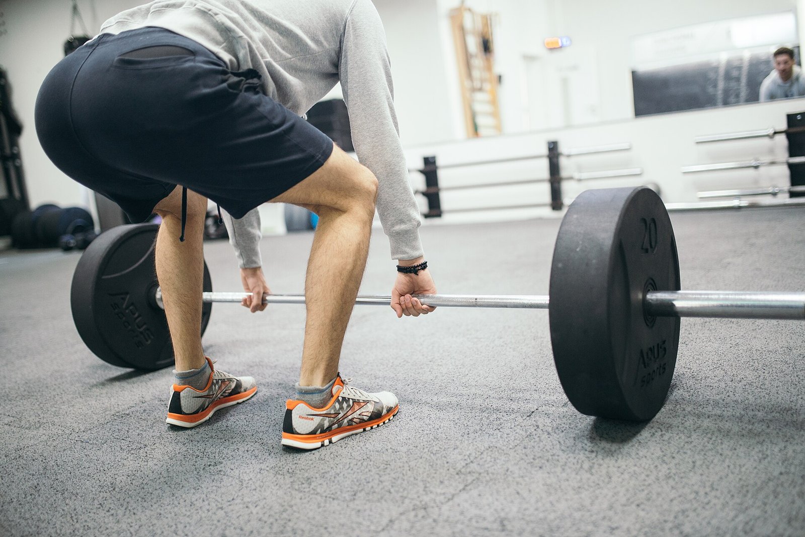 Lifter setting up for a barbell deadlift in a gym
