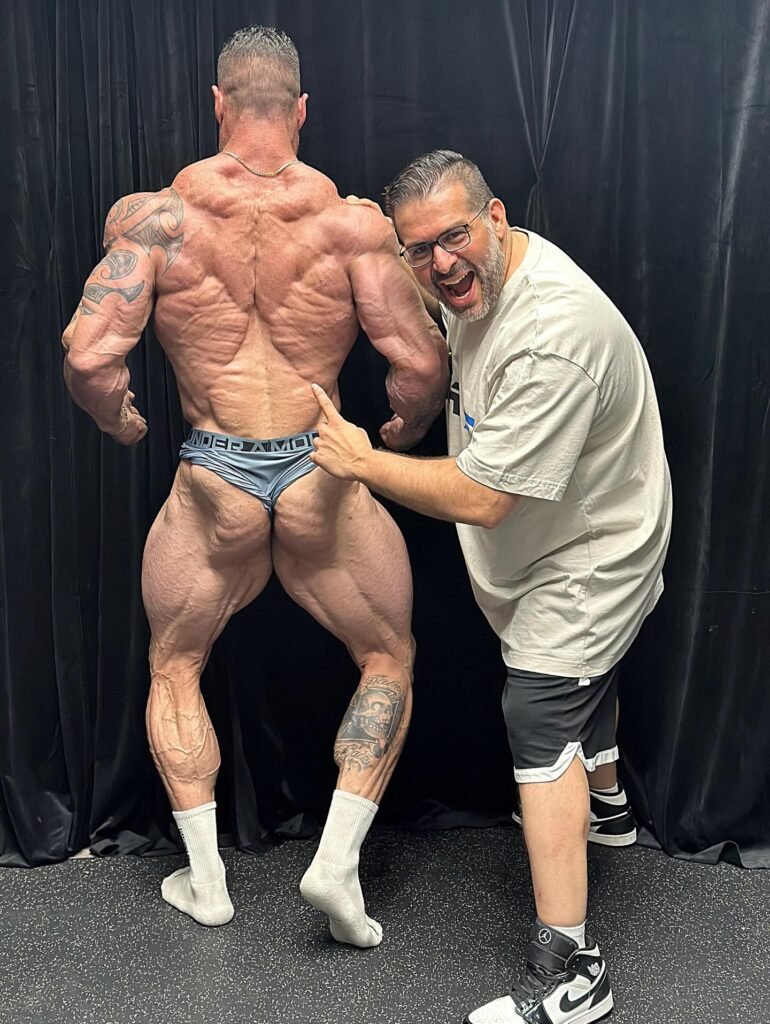 Jesus Rodriguez Sendra hitting a back pose during Olympia week in Las Vegas, October 2025, with his coach