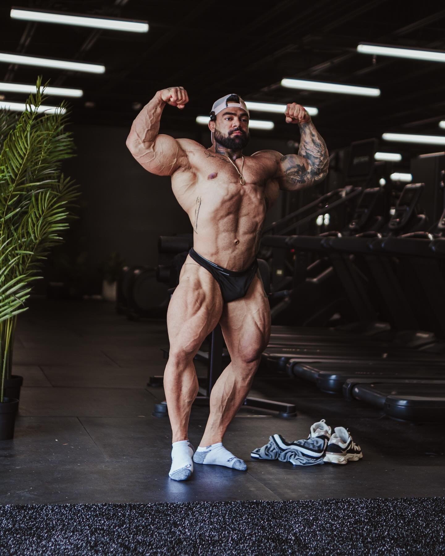 Bruno Santos performing a front double biceps pose during a gym photo shoot