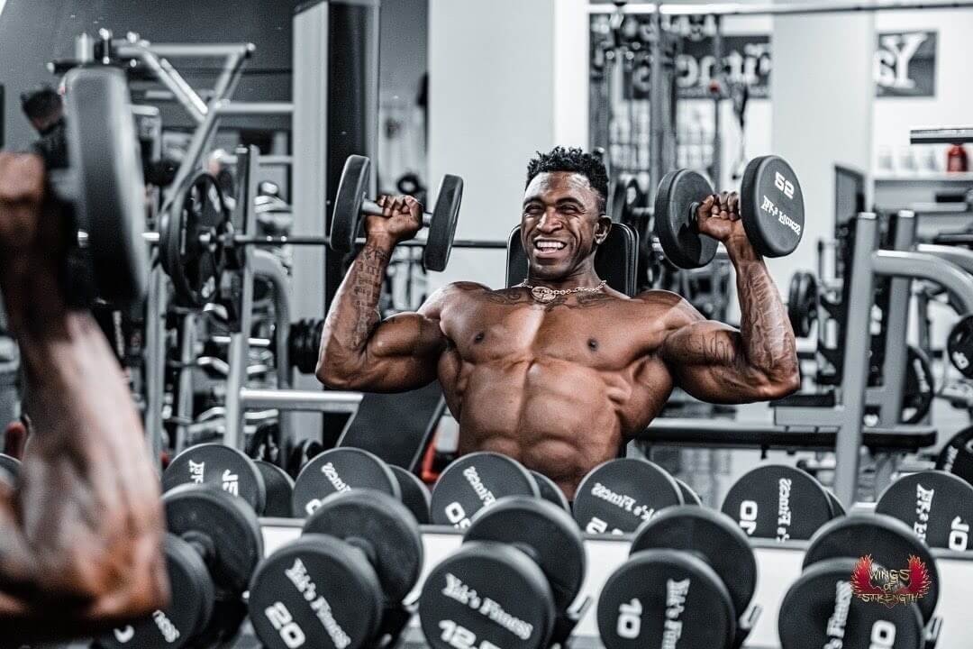 Charjo Grant performing a dumbbell press during a gym workout