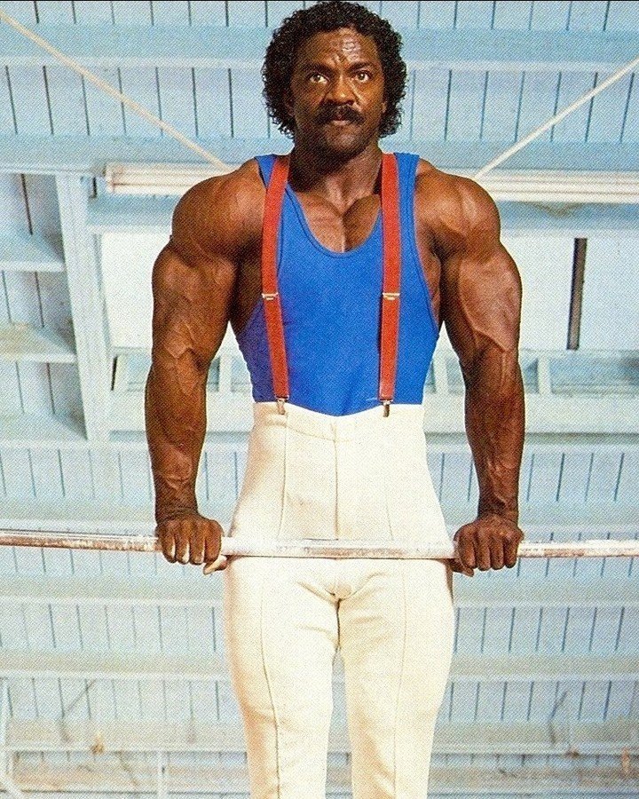 Charles Glass in gymnastics attire, holding a horizontal bar during his years as a competitive gymnast