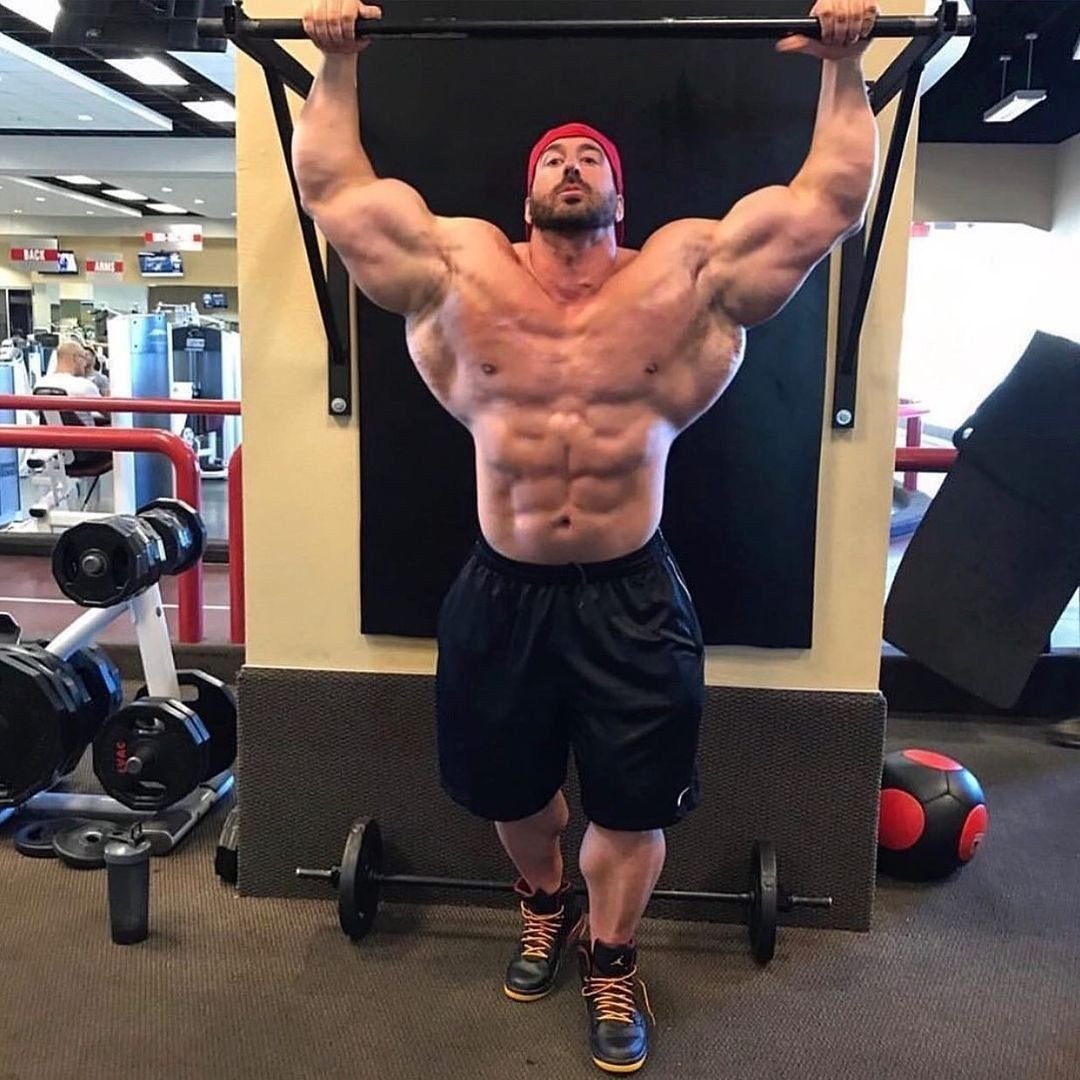 Craig Golias hanging from a pull-up bar, showing his lat width