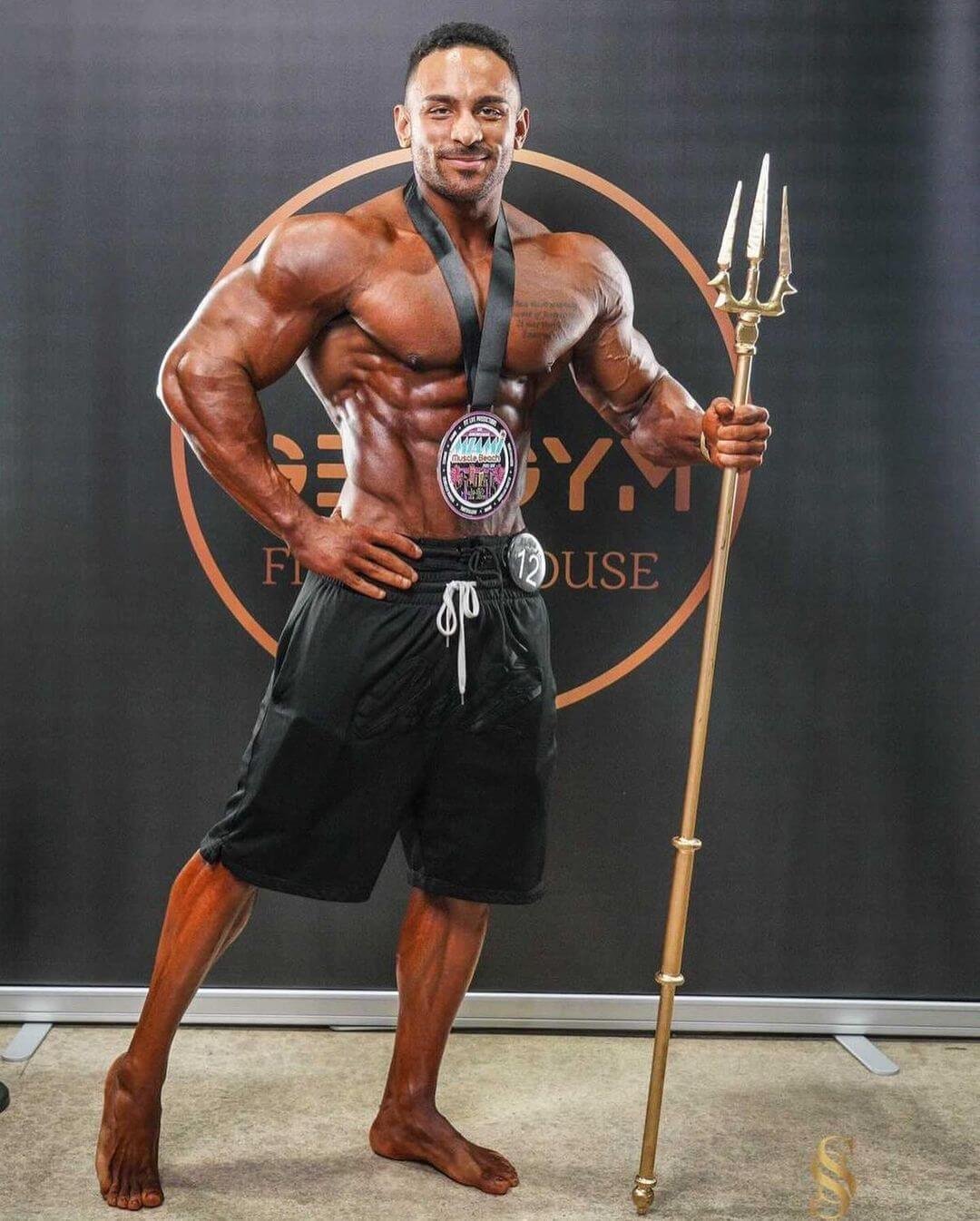 Daniel Ammons full-body winner's pose with Miami Muscle Beach medal and trident