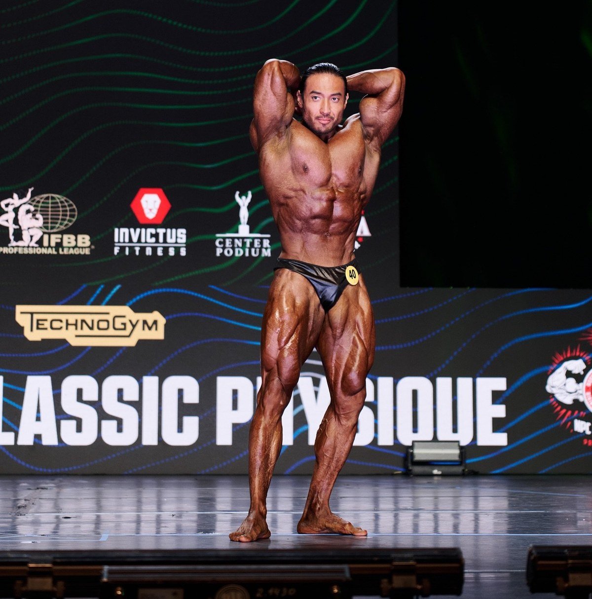 Daryn Shirbayev hitting an abdominal and thigh pose on the Invictus stage in Kazakhstan