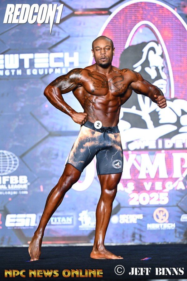 Dustin Alvis posing on the Mr. Olympia stage in Las Vegas in 2025, wearing competitor number 2