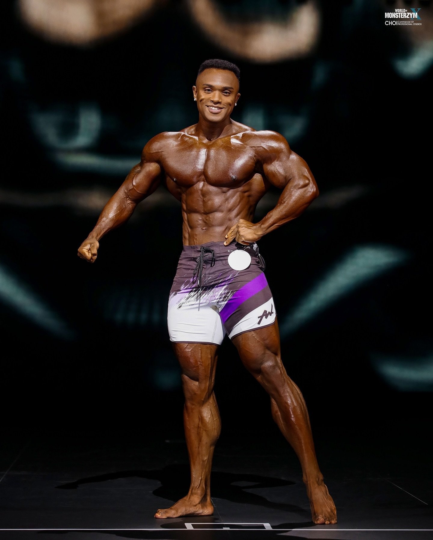 Farouq Ishimoto holding the Official Olympia Qualifier board overhead after winning the 2025 World of Monsterzym Korea Pro