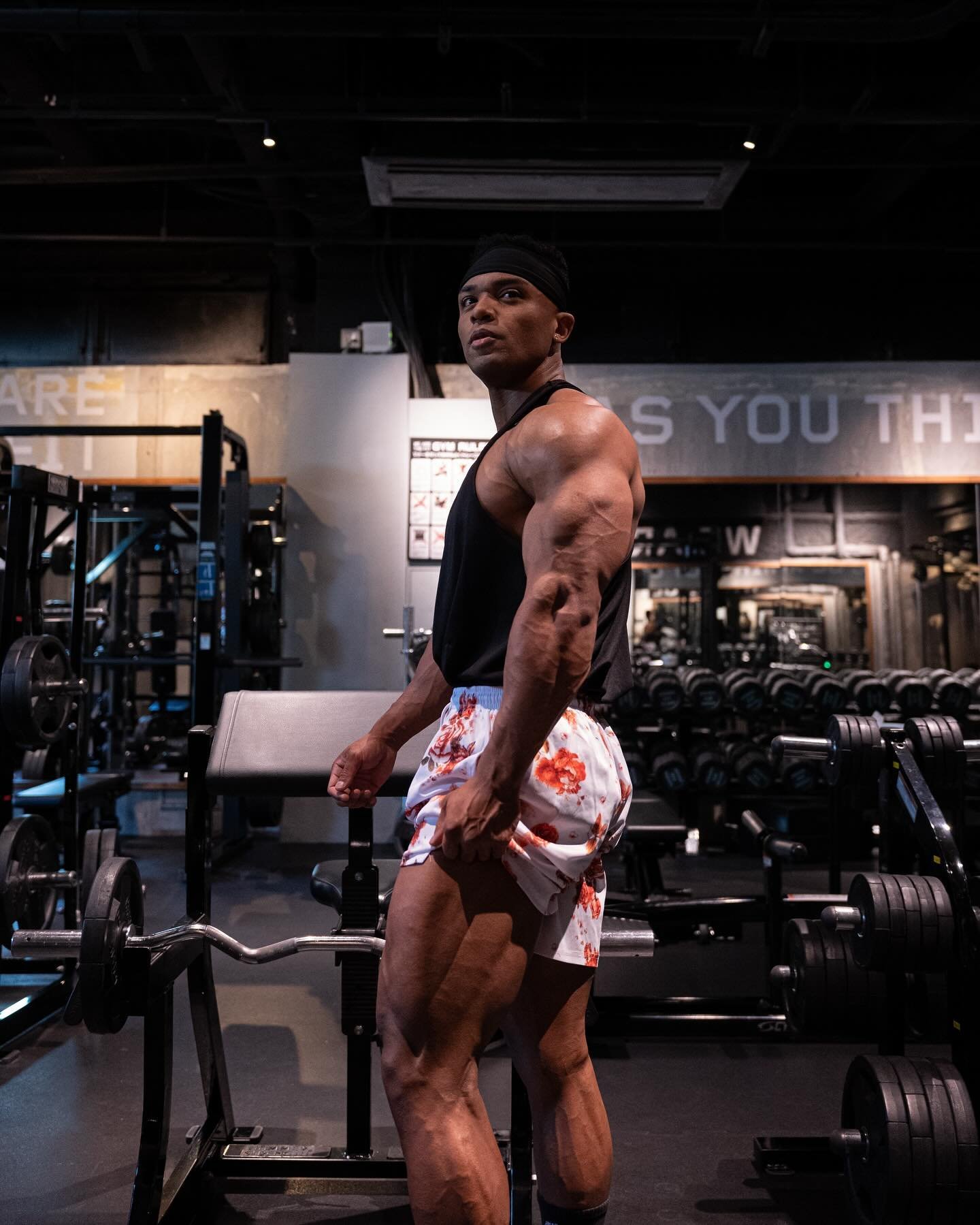 Farouq Ishimoto training in the gym in a black tank top and floral shorts
