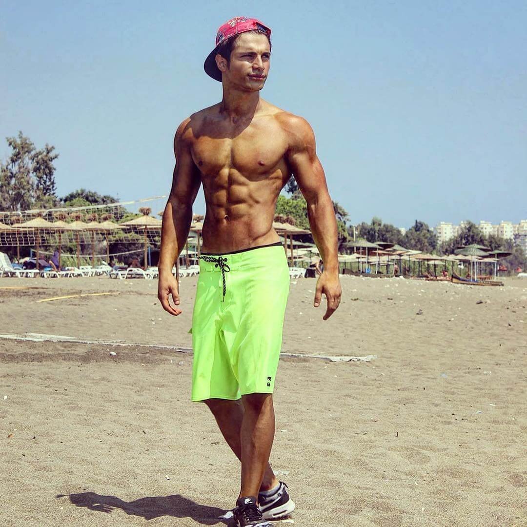 Young Furkan Er outdoors in board shorts