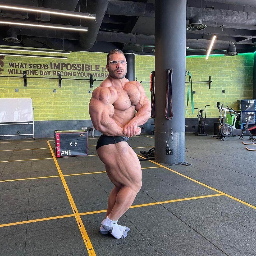 Hassan Mostafa performing a side chest pose during a gym check-in