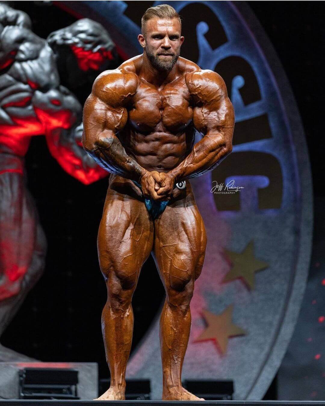 Iain Valliere hitting a front pose on stage