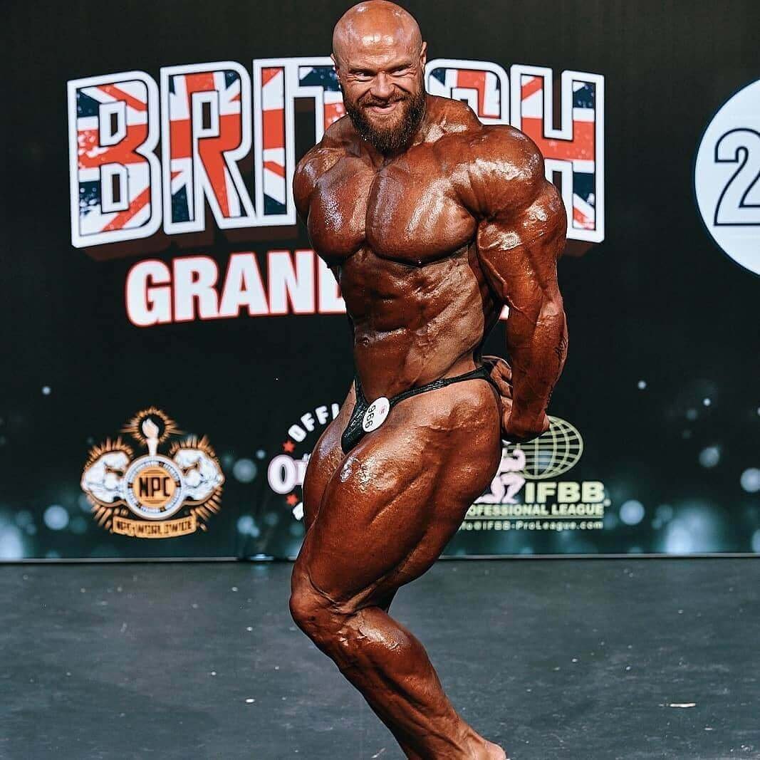 James Hollingshead hitting a side chest pose on stage