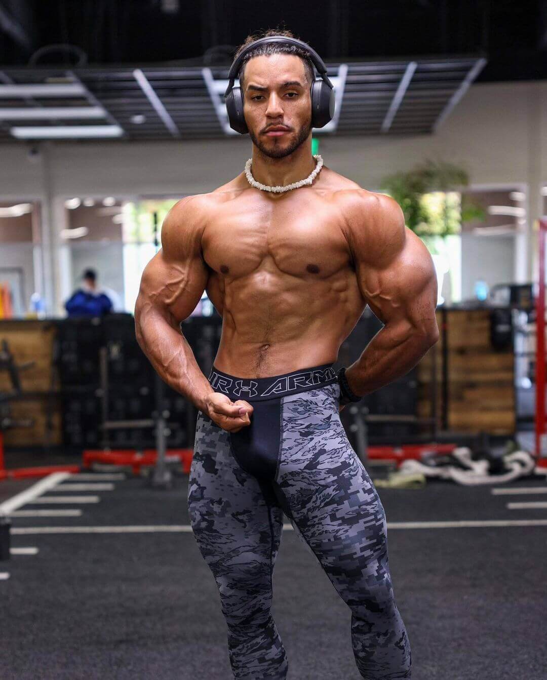 Joshua Manoi facing the camera in a gym, showing his chest and arms