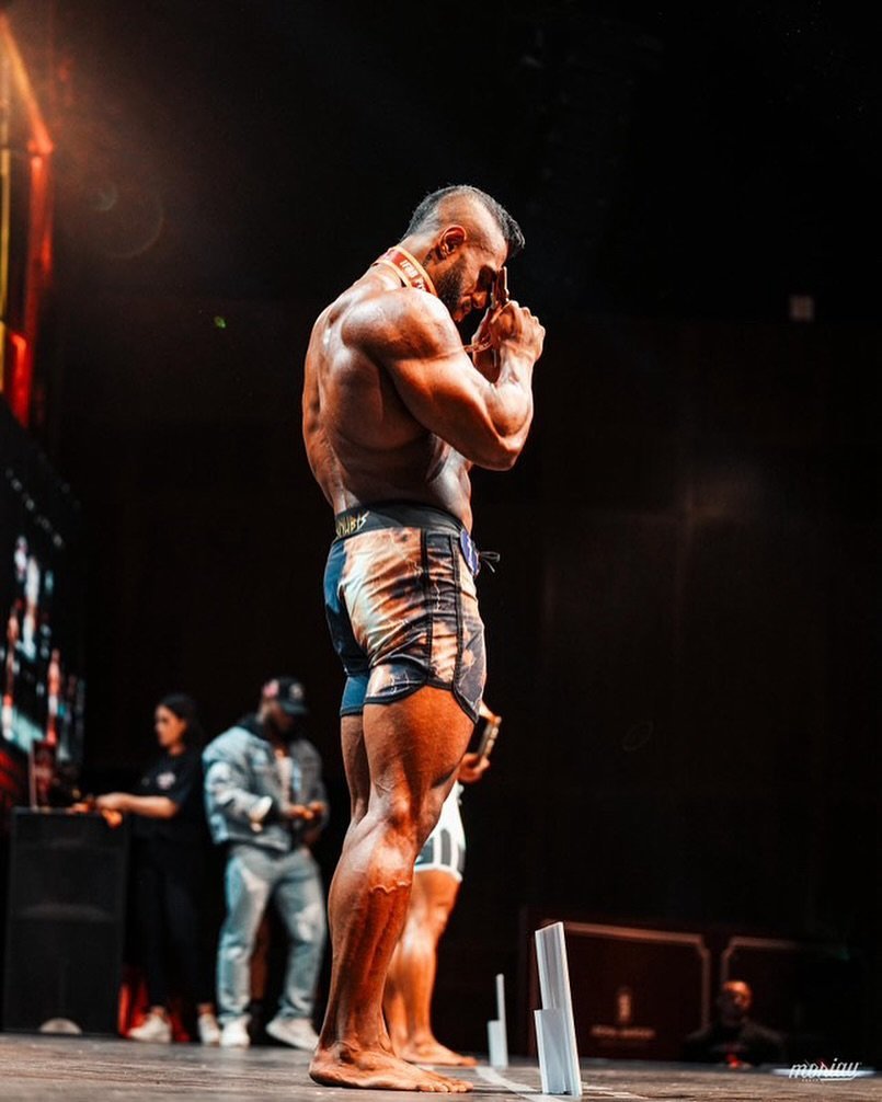 Juan Gochez wearing his medal on stage, holding it in an emotional moment
