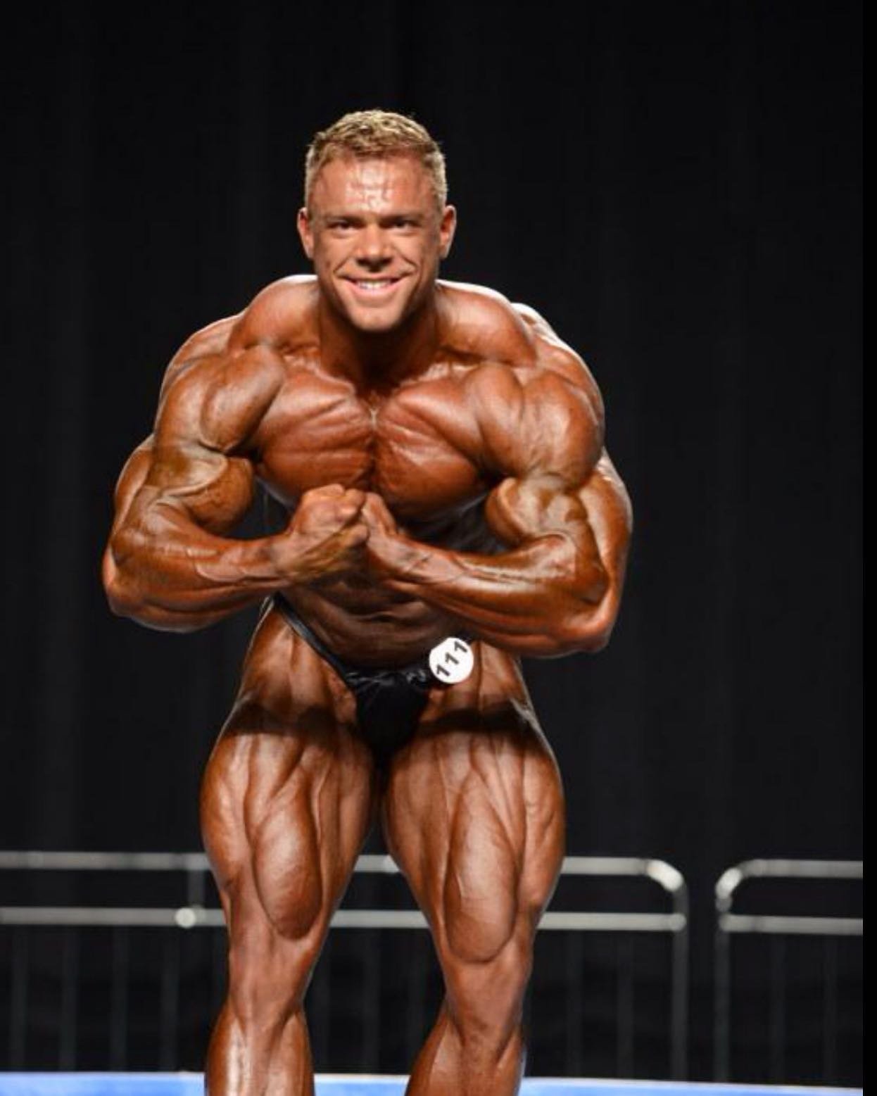 Justin Compton hitting a most muscular pose on a pro bodybuilding stage