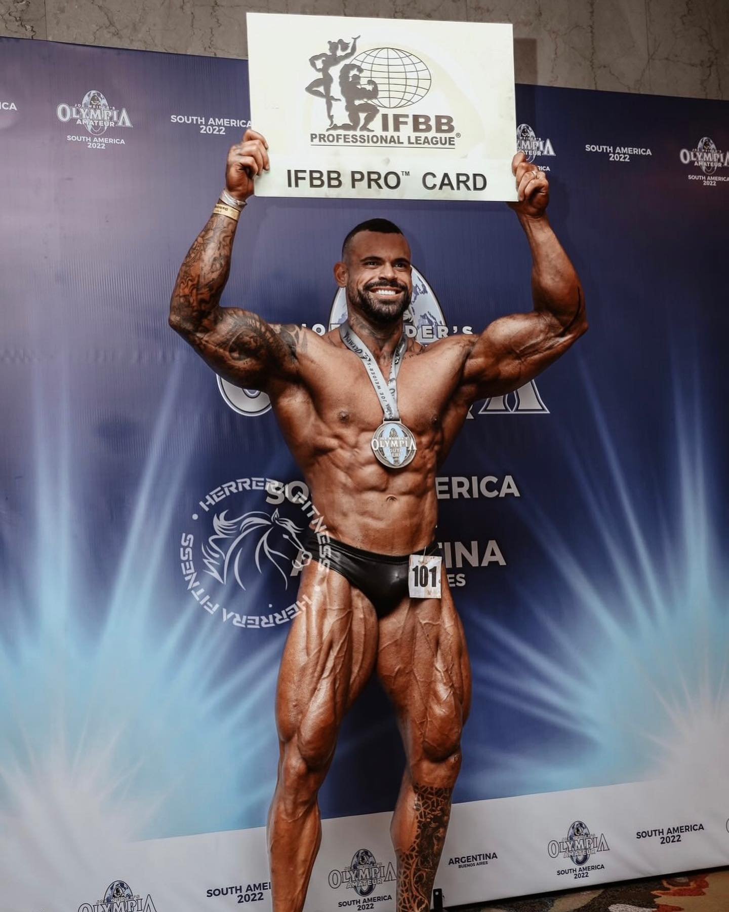 Kenny Moreira holding his IFBB Pro Card at the Olympia Amateur South America 2022 in Buenos Aires