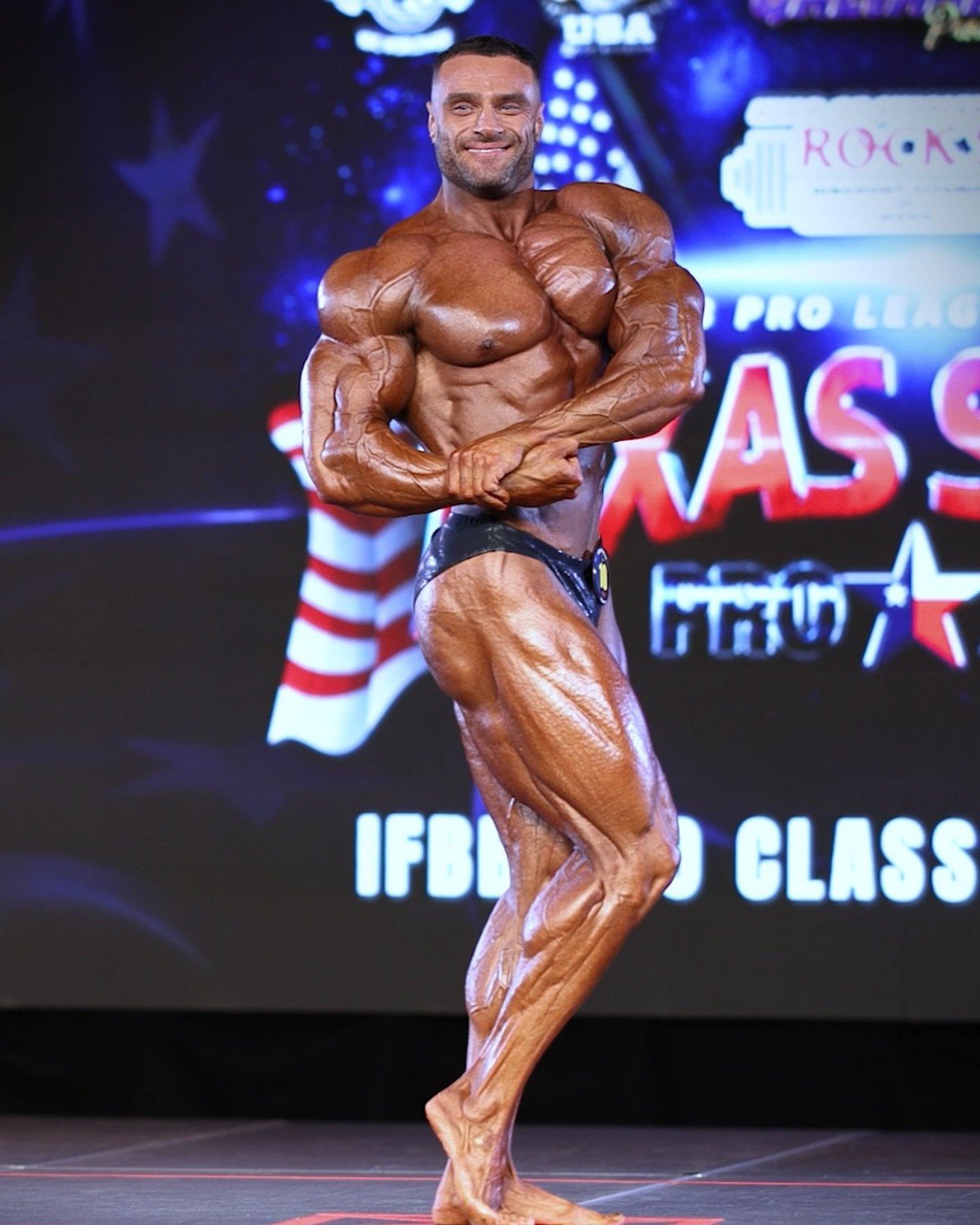Kyrylo Khudaiev performing a side chest pose on the Texas State Pro stage