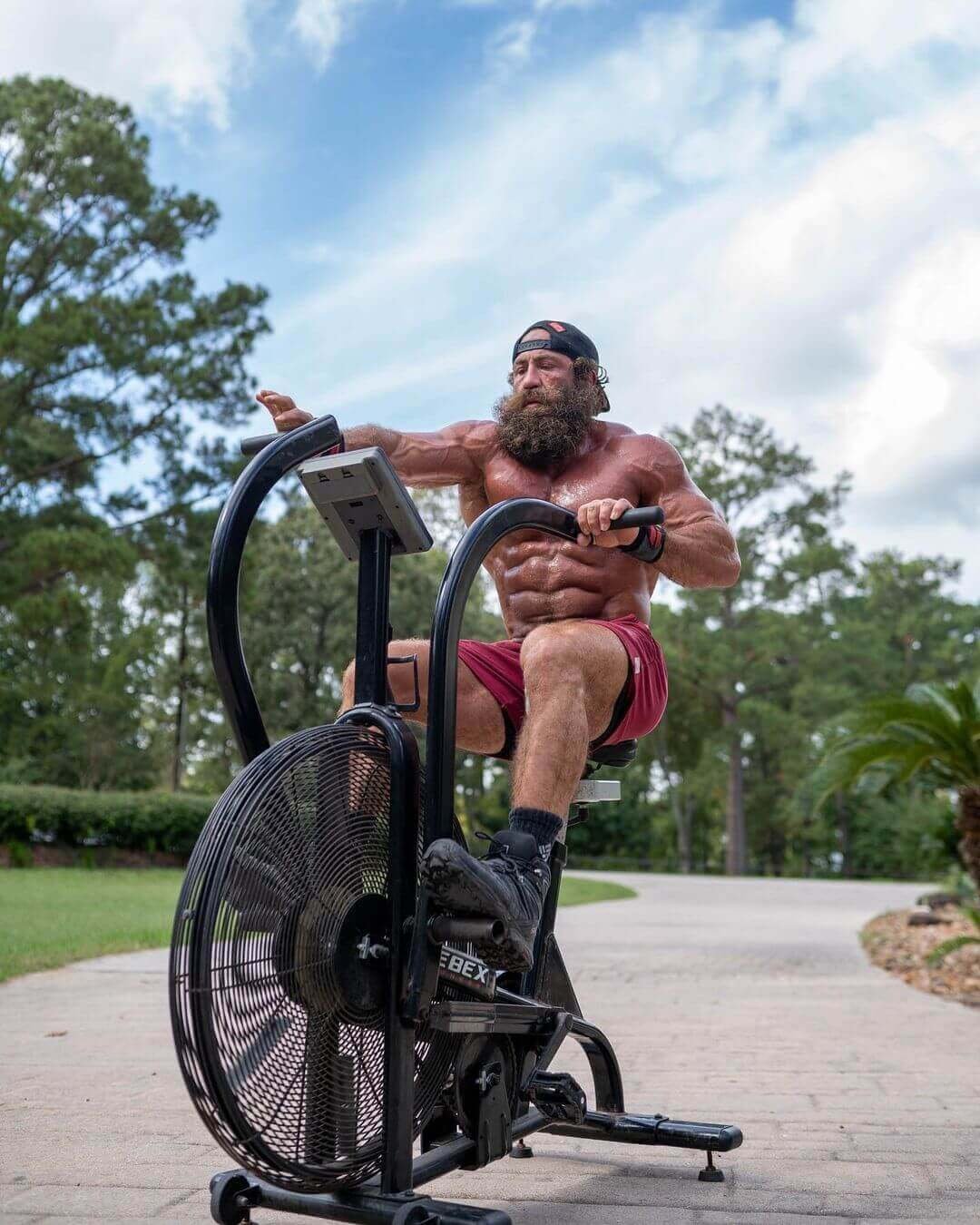 Liver King training on an air bike