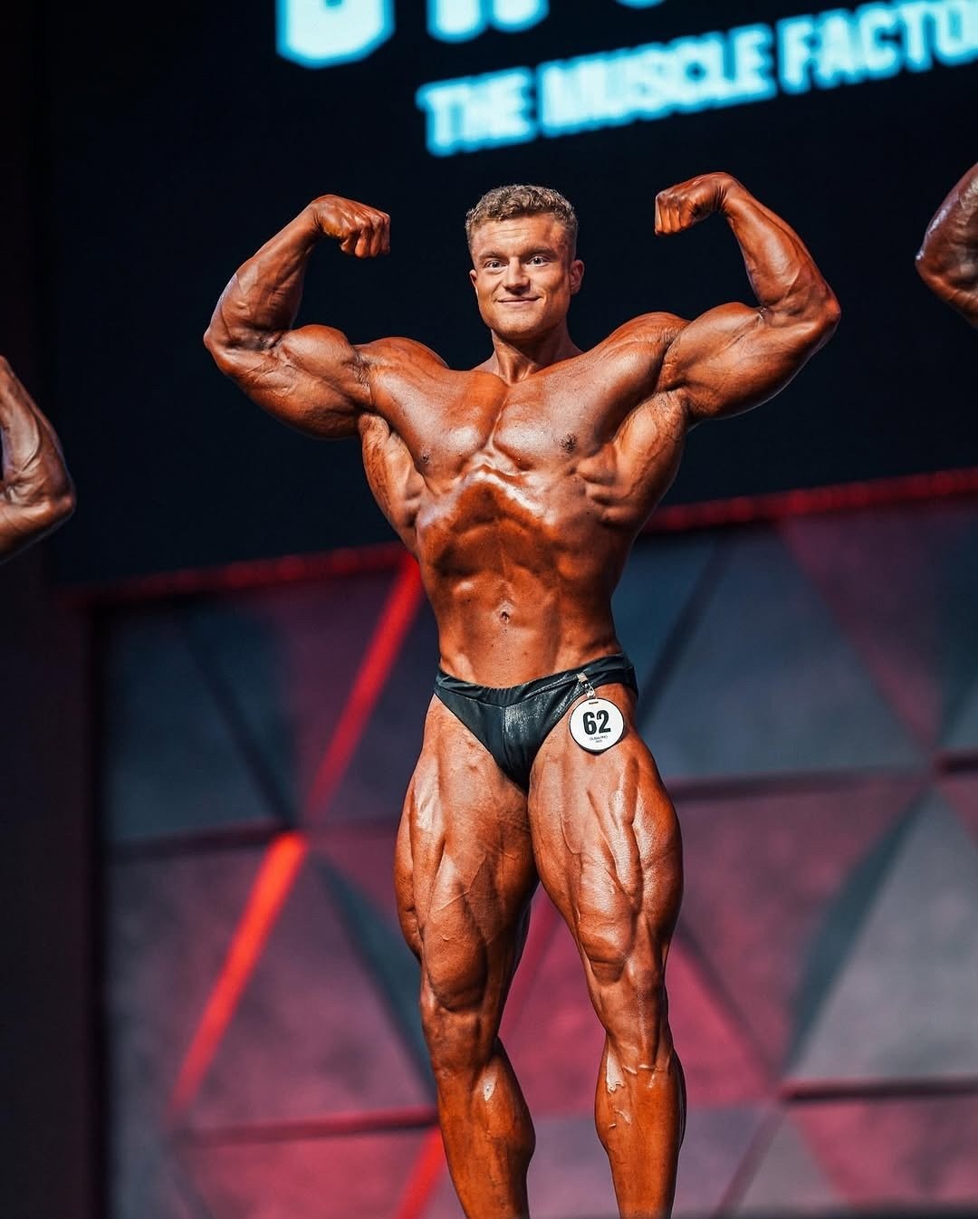Luca Reger hitting a front double biceps pose on an IFBB Pro League stage