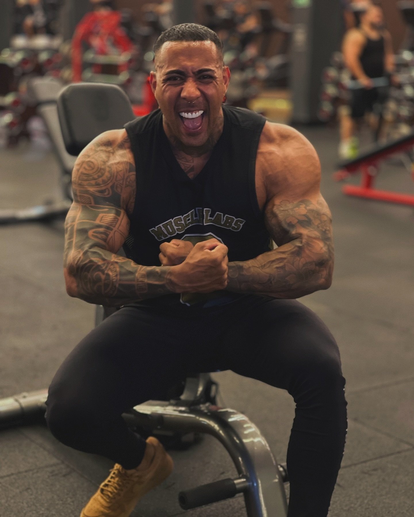 Lucas Viudes flexing and smiling during a gym training session