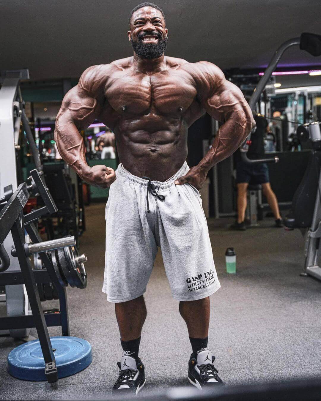 Marc Hector posing in the gym showing his chest and arms