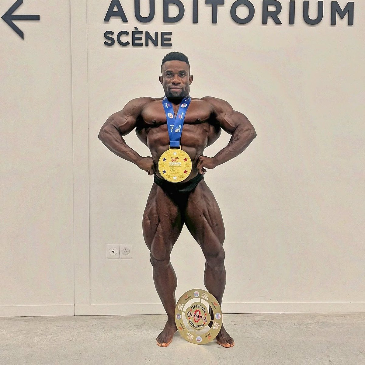 Miguel Malimo backstage with his winner's medal and Official Olympia Qualifier plaque after the 2024 Tsunami Nutrition Showdown Pro in France