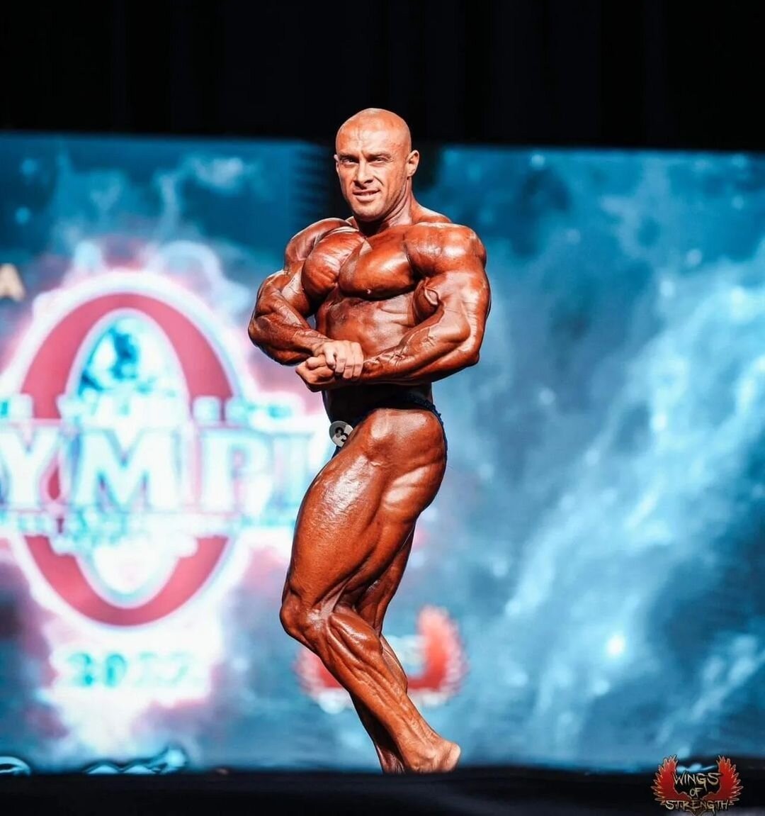 Radoslav Angelov hitting a side-chest pose on stage
