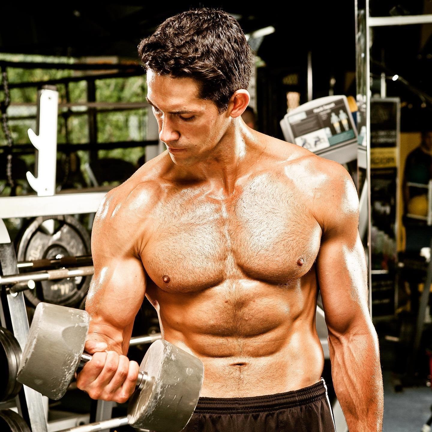 Scott Adkins training with a heavy dumbbell in the gym