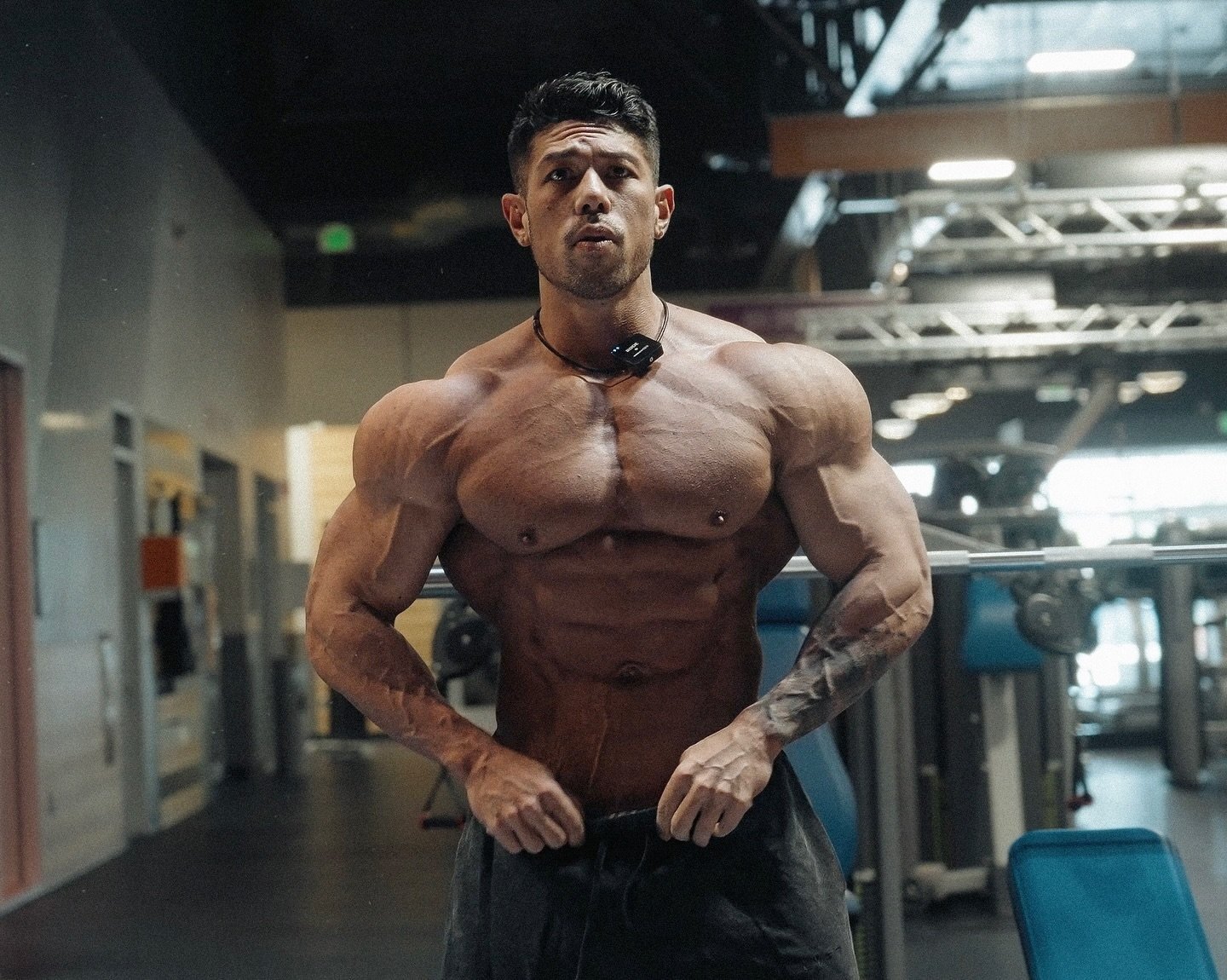 Shun Kaneko hitting a front pose in the gym