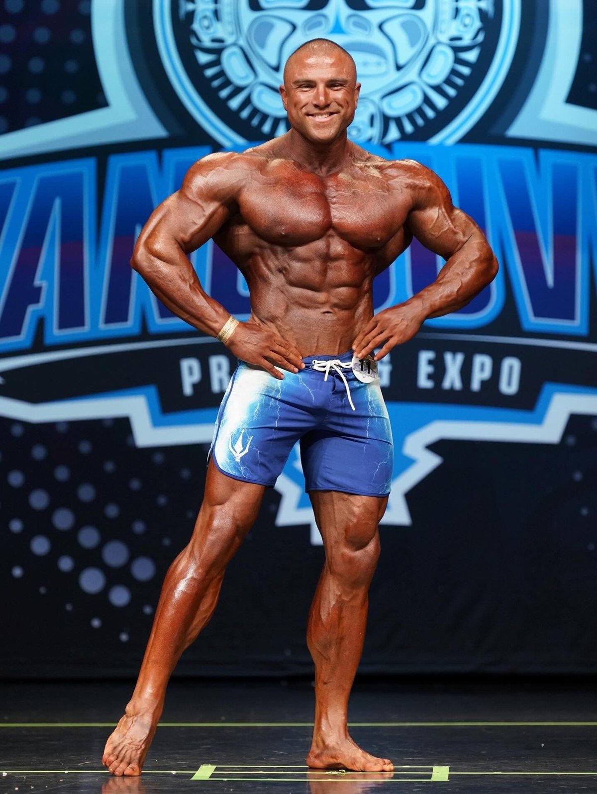 Sotiris Gatsis posing on stage at the 2025 Vancouver Pro, which he won with a perfect score