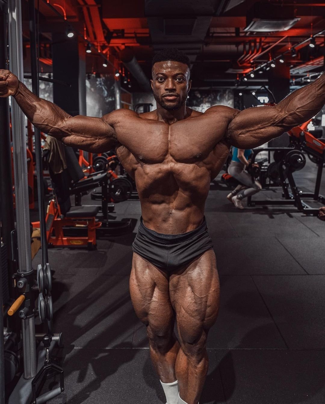 Stephane Matala posing with arms outstretched in the gym