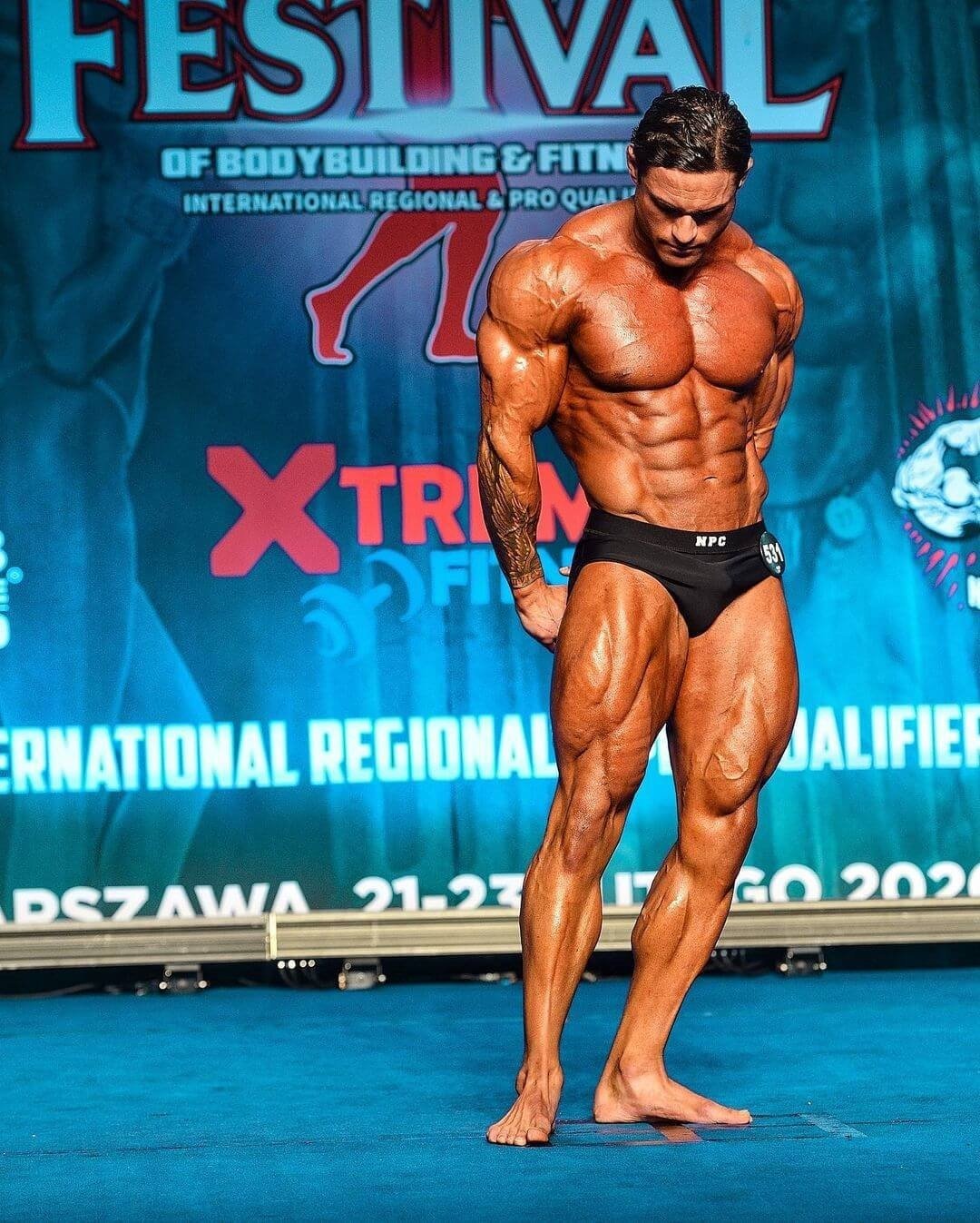 Tavi Castro posing on stage at the 2020 NPC Worldwide Festival in Warsaw