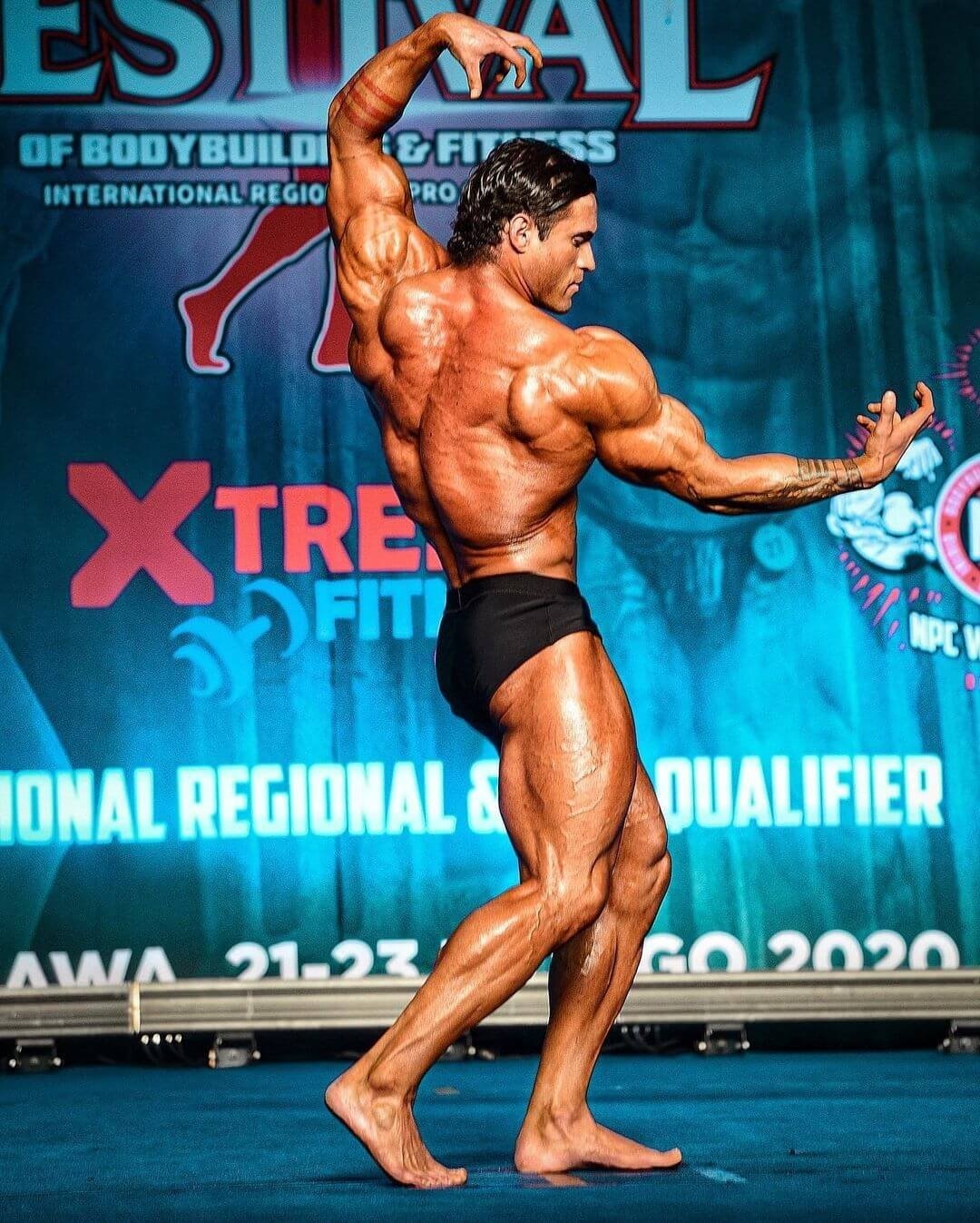 Tavi Castro hitting a back pose on stage in 2020