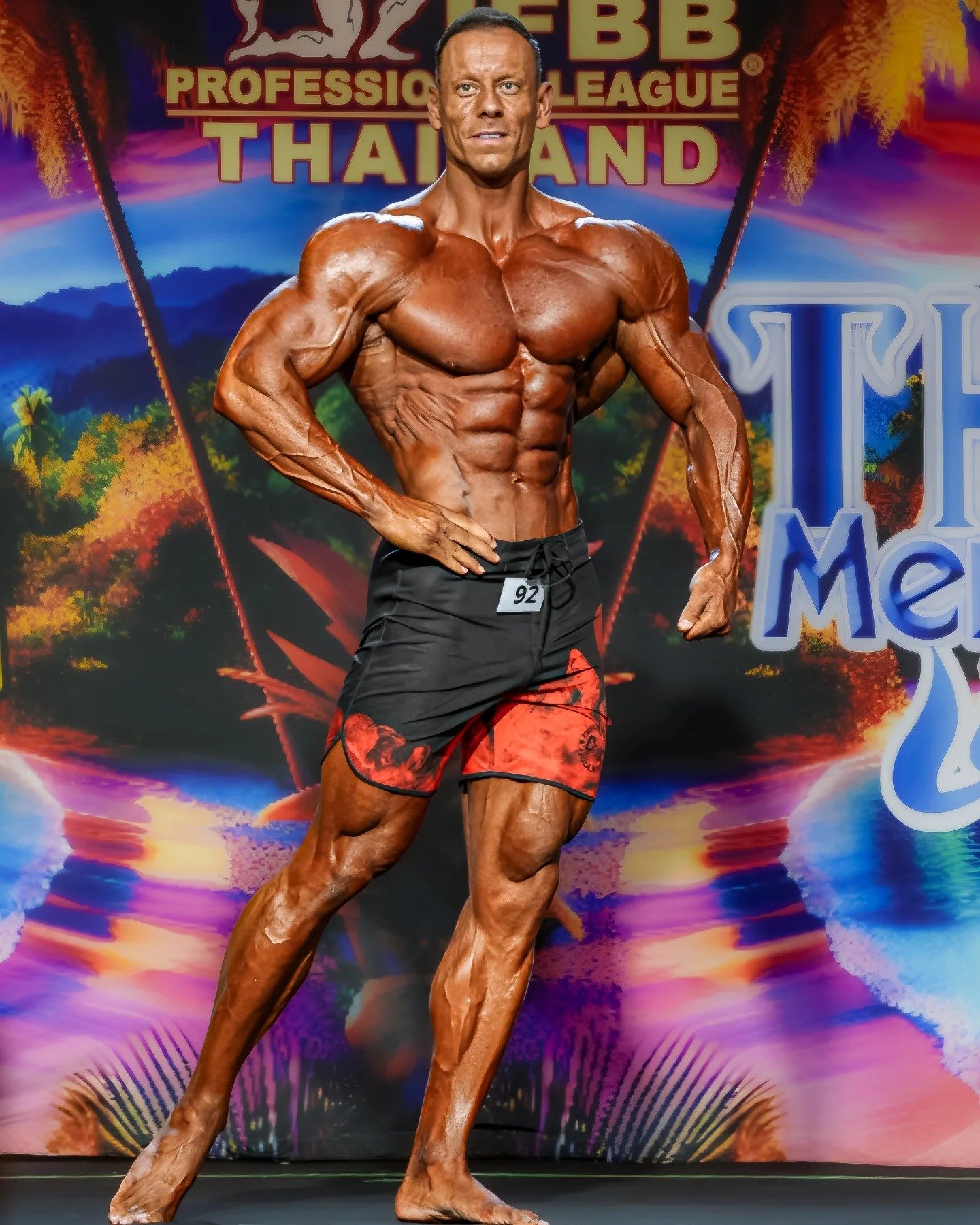 Tyler Smith posing on stage at the 2025 Thailand Pro in Pattaya, wearing competitor number 92