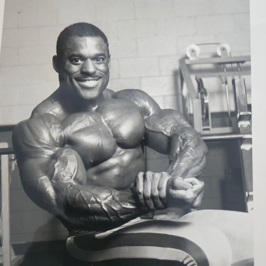Vince Taylor hitting a side chest pose in the gym during his prime